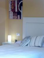 a bedroom with a white bed with a picture on the wall at Casa Valdevaqueros in Tarifa