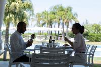 Un uomo e una donna seduti a tavola mangiando cibo di Infinity Resort Tropea a Parghelia