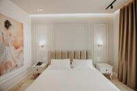 Un dormitorio con una gran cama blanca y una pintura en Seaside Hotel, en Vlorë