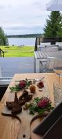ein Holztisch mit Essen und einem Glas Wein in der Unterkunft Hotel Aateli Lakeside in Vuokatti