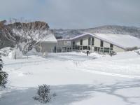 a snow covered yard with a building in the background at Sundeck Hotel in Perisher Valley