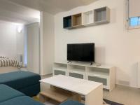 a living room with a tv and a couch and a table at Charming intim apartment in Paris South in Montrouge