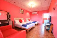 a red room with two beds and a couch at Fumigate Hotel in Hengchun South Gate