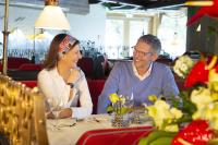a man and woman sitting at a table in a restaurant at Hotel Vier Jahreszeiten am Schluchsee in Schluchsee
