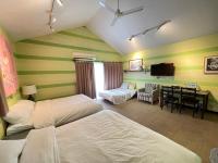 a hotel room with two beds and a desk with a television at Star Wish B&amp;B in Dongshan