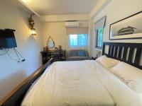 a bedroom with a white bed and a chair at Star Wish B&amp;B in Dongshan