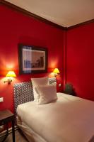 a bedroom with red walls and a bed with two lamps at Hôtel du Danube Saint Germain in Paris