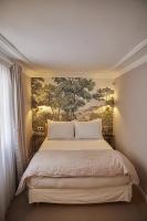 a bedroom with a bed with a painting on the wall at Hôtel du Danube Saint Germain in Paris
