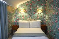 a bedroom with a bed with floral wallpaper at Hôtel du Danube Saint Germain in Paris