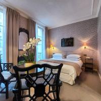 a bedroom with a large bed and a table and chairs at Hôtel du Danube Saint Germain in Paris