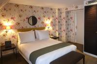 a bedroom with a large bed with floral wallpaper at Hôtel du Danube Saint Germain in Paris