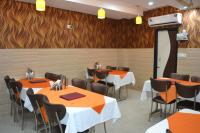 comedor con mesas, sillas y paredes de madera en Hotel Jigyasa By Mayda Hospitality Pvt. Ltd., en Agra