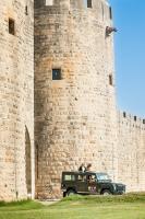 a green jeep parked in front of a castle at Maison Arthur in Aigues-Mortes