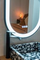 a mirror on a shelf with a bed in a room at Maison Arthur in Aigues-Mortes