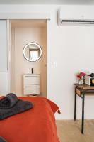 a bedroom with a red bed and a mirror at Maison Arthur in Aigues-Mortes