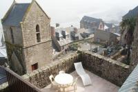 a building with a table and chairs on a balcony at La Vieille Auberge in Le Mont Saint Michel