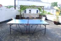a ping pong table on a patio with two chairs at Un jardin en ville in Nantes