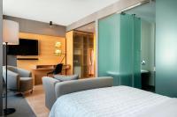 a bedroom with a bed and a chair and a tv at Le Méridien Vienna in Vienna