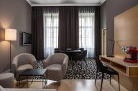 a hotel room with a waiting area with chairs and a table at Le Méridien Vienna in Vienna