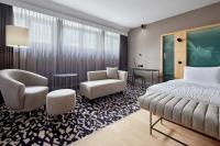 a hotel room with a bed and chairs and a desk at Le Méridien Vienna in Vienna