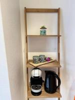 a shelf with cups and a coffee maker on it at Appartement neuf entièrement équipé proche centre in Amiens