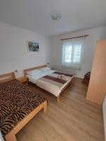 a bedroom with two beds and a window at Family Room Drace 4550a in Drače