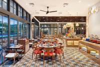 a restaurant with tables and chairs and windows at Sima Sumba Hotel in Tambolaka