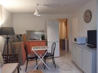 a kitchen with a table and chairs and a clock on the wall at La ferme de Manon in Montferrat