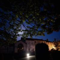 a building at night with a tree in the foreground at Chambres d&#39;Hôtes Bienvenue in LʼAbsie