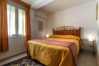 a bedroom with a bed with a yellow blanket and a window at Hotel Casa Boccassini in Venice