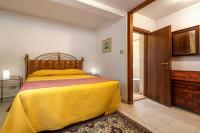 a bedroom with a yellow bed and a bathroom at Hotel Casa Boccassini in Venice