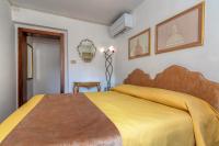 a bedroom with a bed with a yellow blanket at Hotel Casa Boccassini in Venice