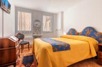 a bedroom with a yellow bed and a desk at Hotel Casa Boccassini in Venice