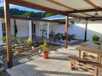 a patio with a table and benches in front of a building at Résidence Ariane in Bourda