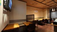 a dining room with tables and chairs and a flat screen tv at Dormy Inn EXPRESS Asakusa in Tokyo