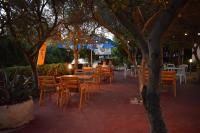 een openluchtrestaurant met tafels, stoelen en bomen bij Panorama Apartments in Povljana