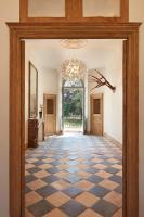 a hallway with a checkered floor and a chandelier at DOMAINE LE MEZO in Ploeren