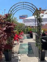 Un cenador con plantas en un patio con mesas y sillas. en Hotel Virginia, en Garda