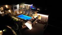 an aerial view of a house at night with a swimming pool at Villa Magic look in Donji Proložac