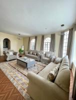 a large living room with couches and a table at Deluxe Apartment in Muscat