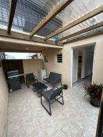 a patio with chairs and tables and a roof at Appartement Le Tangor in Saint-Leu