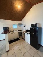 a kitchen with a black refrigerator and white appliances at Appartement Le Tangor in Saint-Leu
