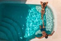 two people swimming in a swimming pool at Aspaki by Art Maisons in Oia