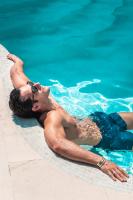 a man laying in the water in a swimming pool at Aspaki by Art Maisons in Oia