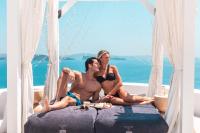 a man and a woman sitting on a bed at Aspaki by Art Maisons in Oia