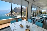 a restaurant with tables and chairs and a view of the ocean at Hotel Saint Christophe in Calvi