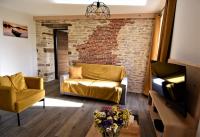 - un salon avec un canapé et un mur en briques dans l&#39;établissement La cure du Petit Doubs, à Rang