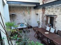 an outdoor patio with a wooden table and chairs at Loft en duplex 270 m2 &amp; Jardin patio terrasse sauna in Chaville