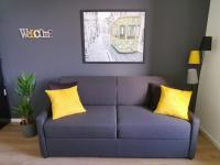 a purple couch with yellow pillows in a living room at LE MEDITERRANEEN *T2 (40m²) *WIFI*PARKING PRIVE* in Lourdes