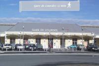 a large building with cars parked in a parking lot at LE MEDITERRANEEN *T2 (40m²) *WIFI*PARKING PRIVE* in Lourdes